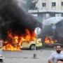 Syrians gathered in front of a burning car at the site of a suicide blast in Tartus, Syria, on Monday.